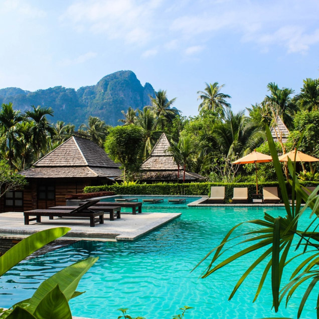 a resort with a pool surrounded by palm trees